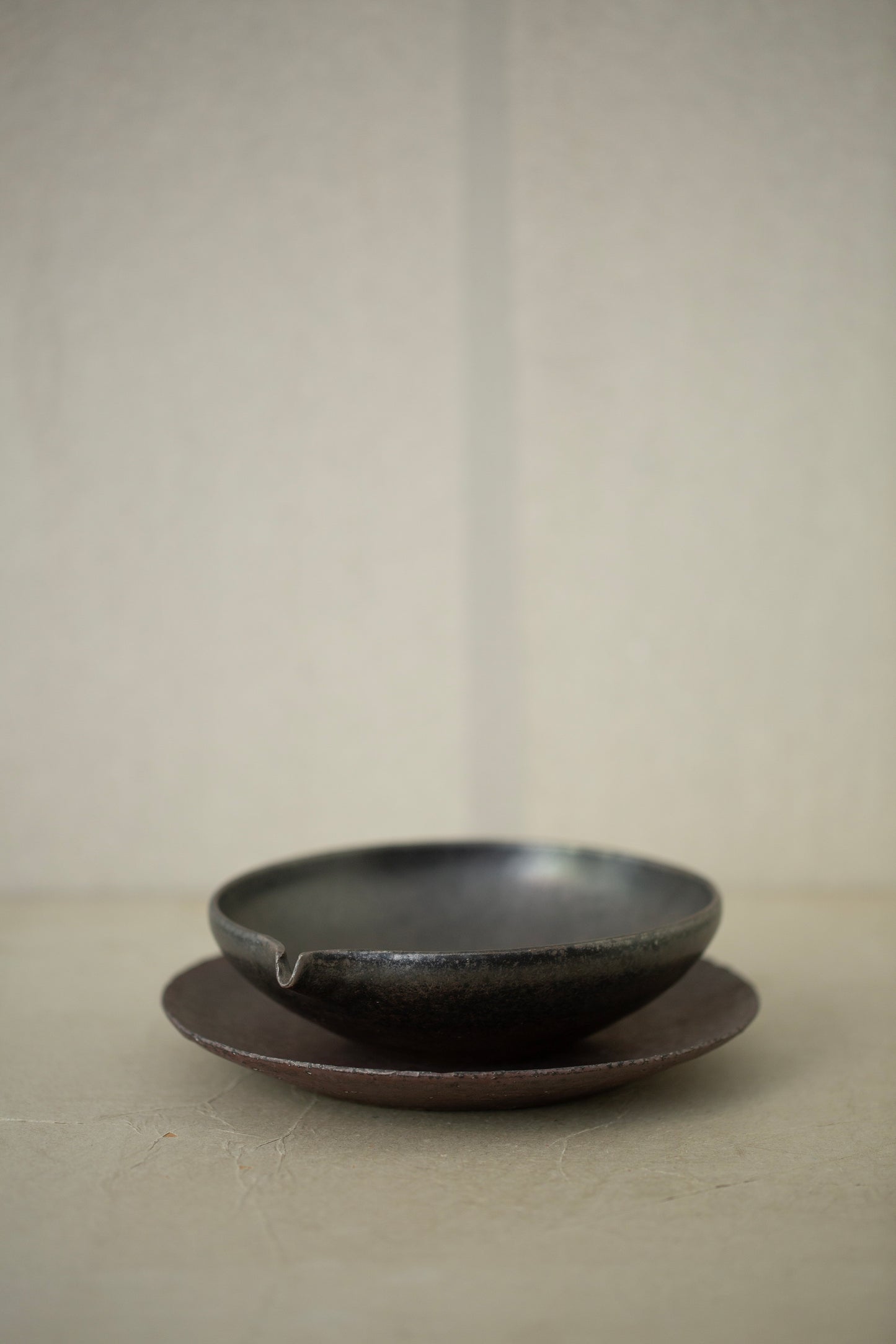 Ceramic sake pourer + saucer by Yohji Matsumiya