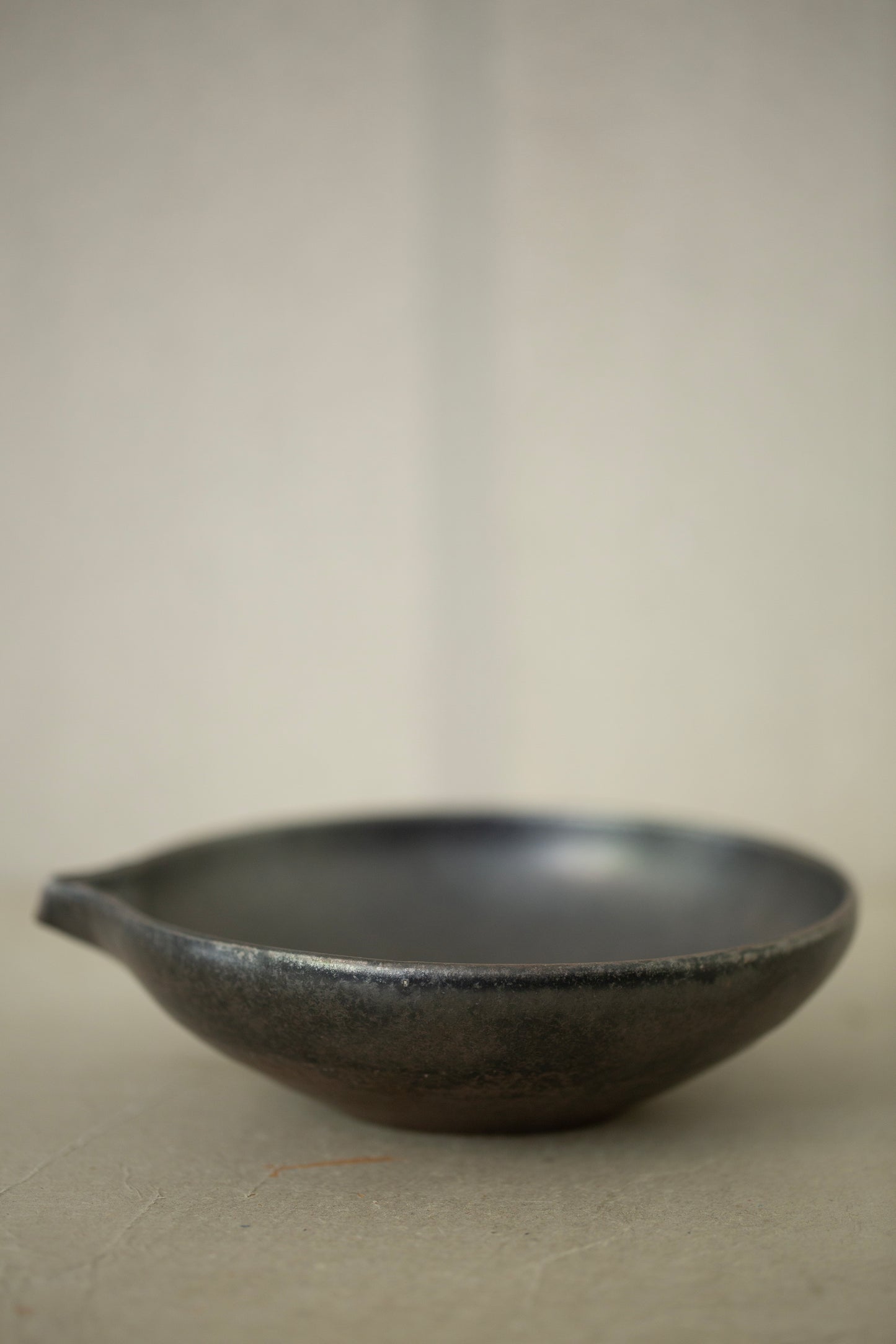 Ceramic sake pourer + saucer by Yohji Matsumiya